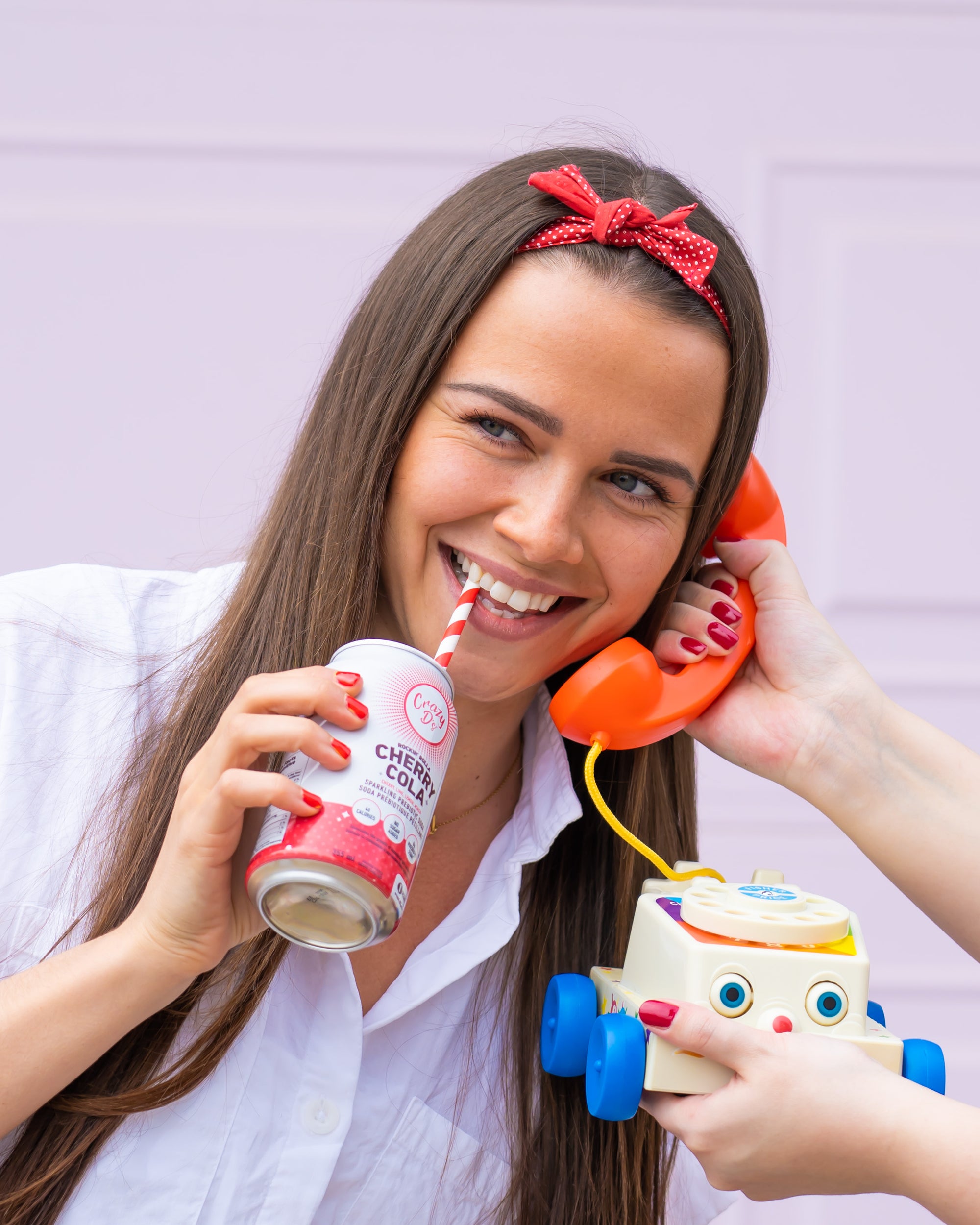 Woman drinking a Crazy D's Rockin' Rolla Cherry Cola Sparkling Prebiotic Soda.